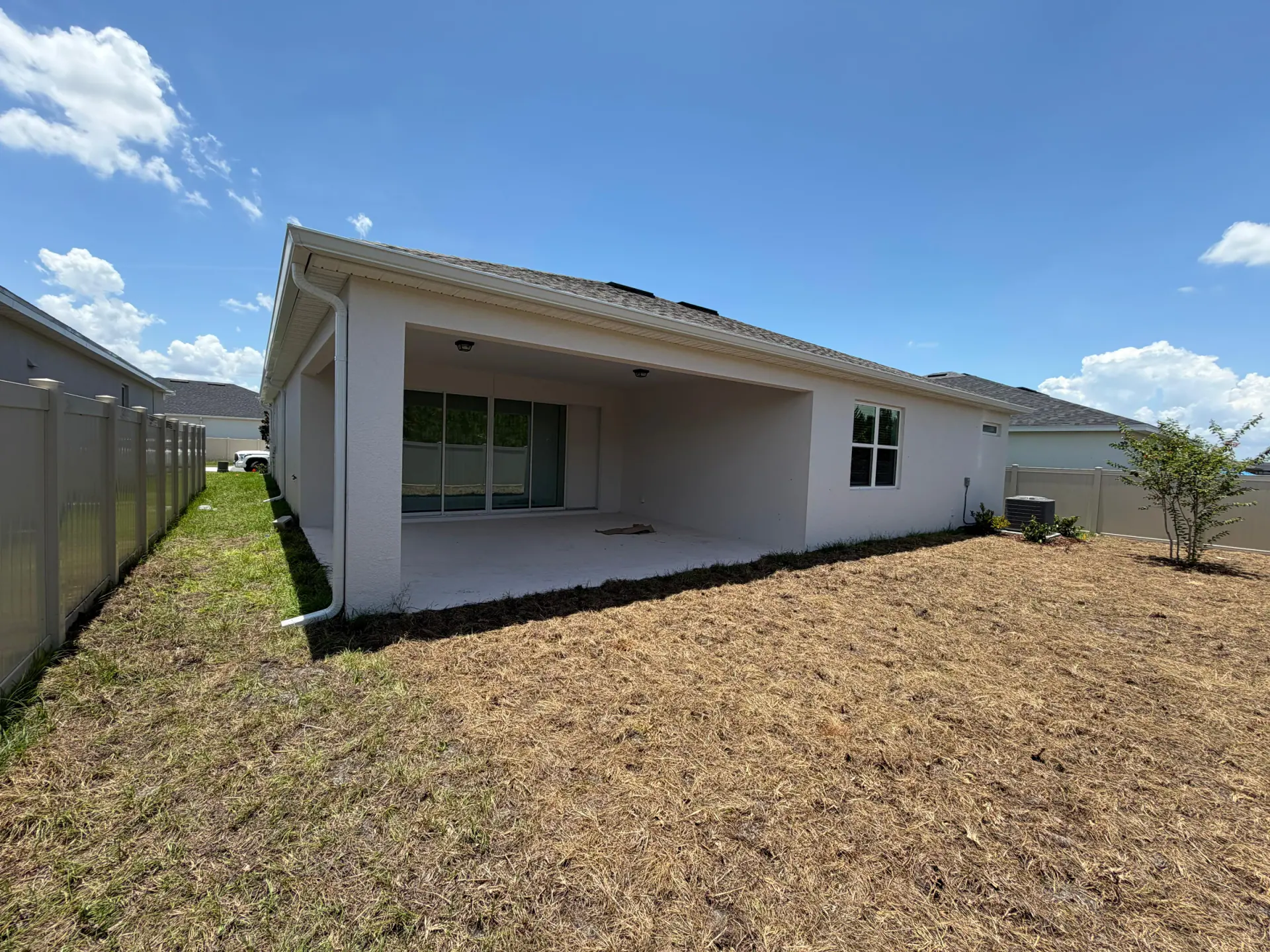 Residential covered patio with a downspout positioned along the left roof-edge corner