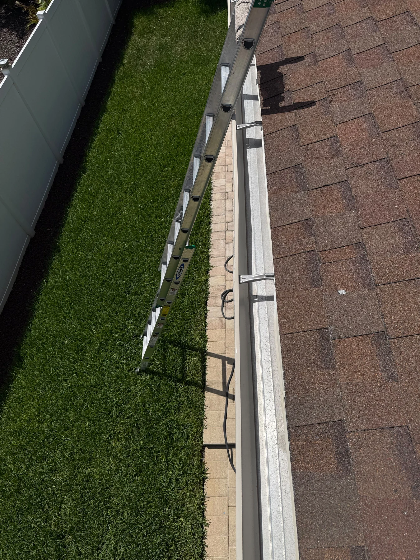 Elevated roof-edge work view with ladder and shingle detail in Dr. Phillips, Orlando