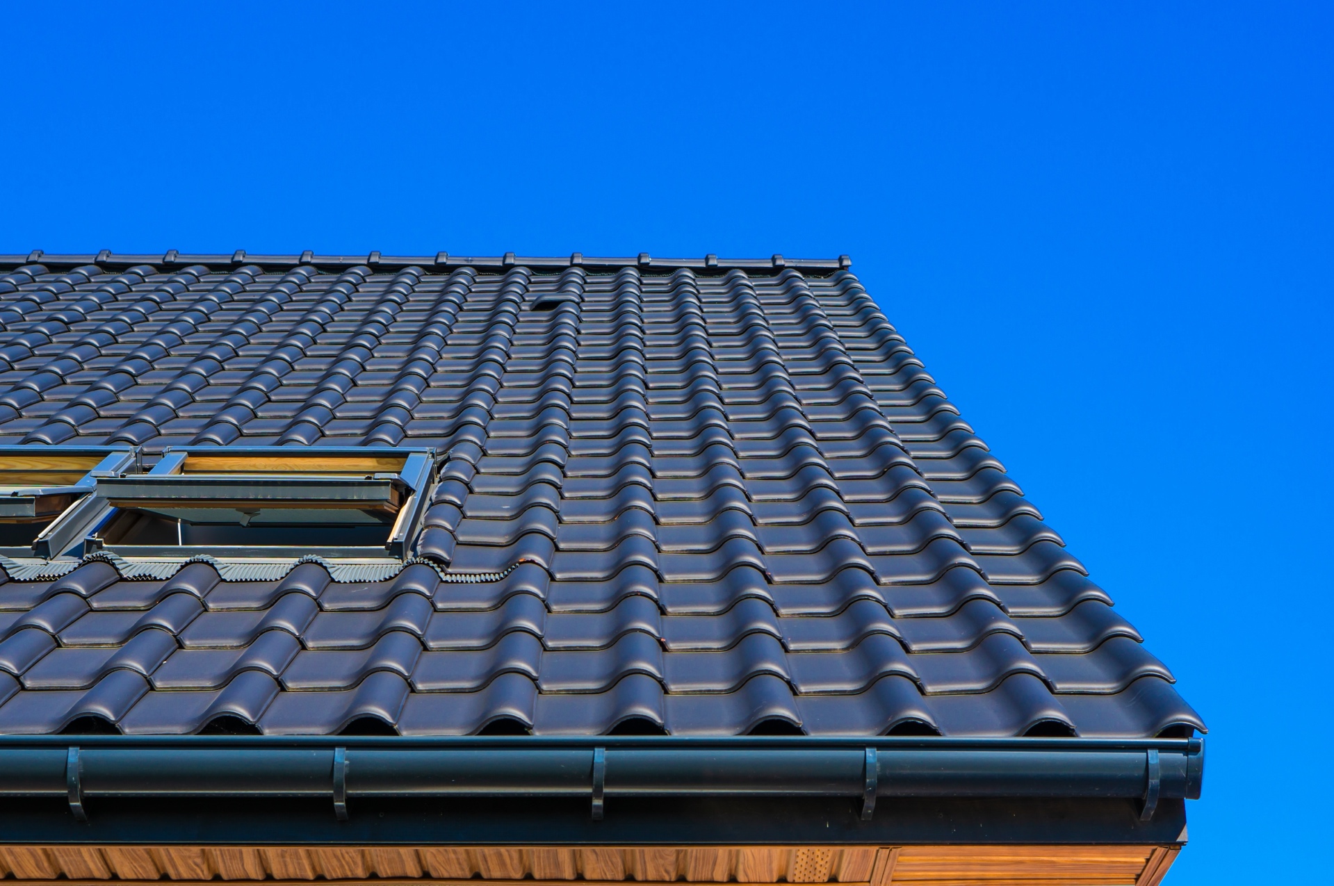 Dark gutter following the lower edge of a dark tile roof at a PrimeFlow project in Montverde, Florida