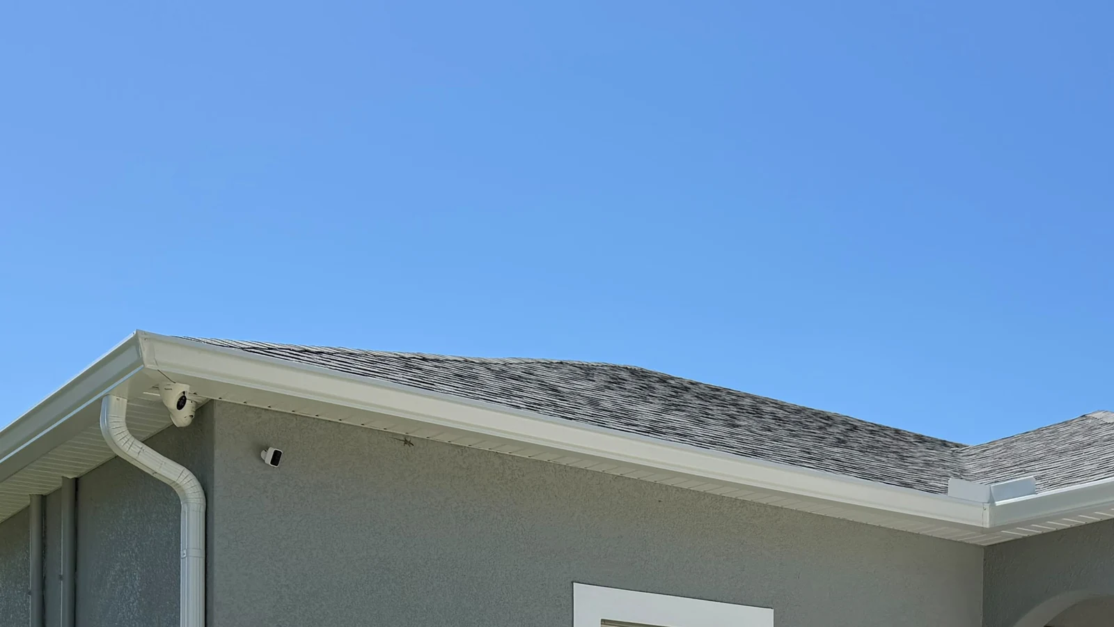 White gutter corner and downspout at a residential roof edge in Sarasota