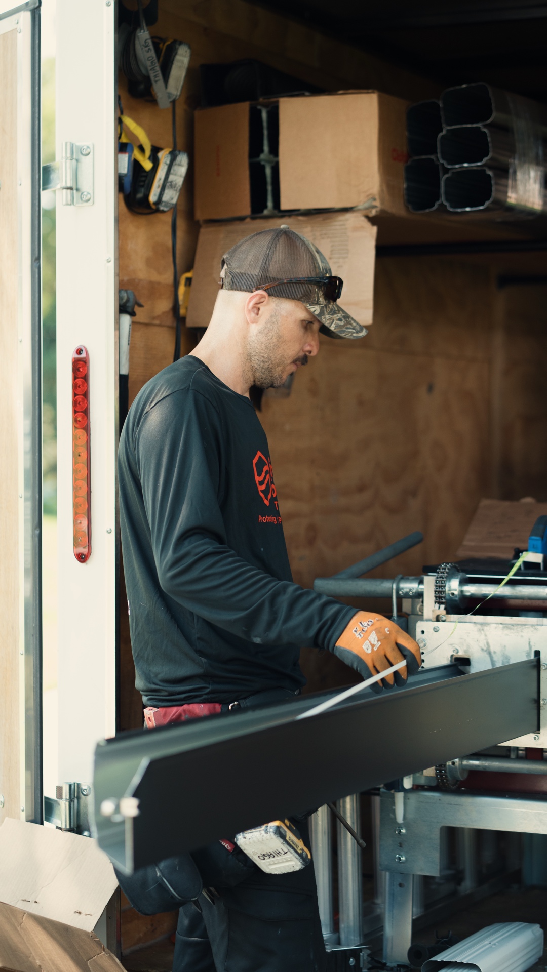 Thiago, PrimeFlow Gutters project field manager, preparing seamless gutter material at the fabrication machine