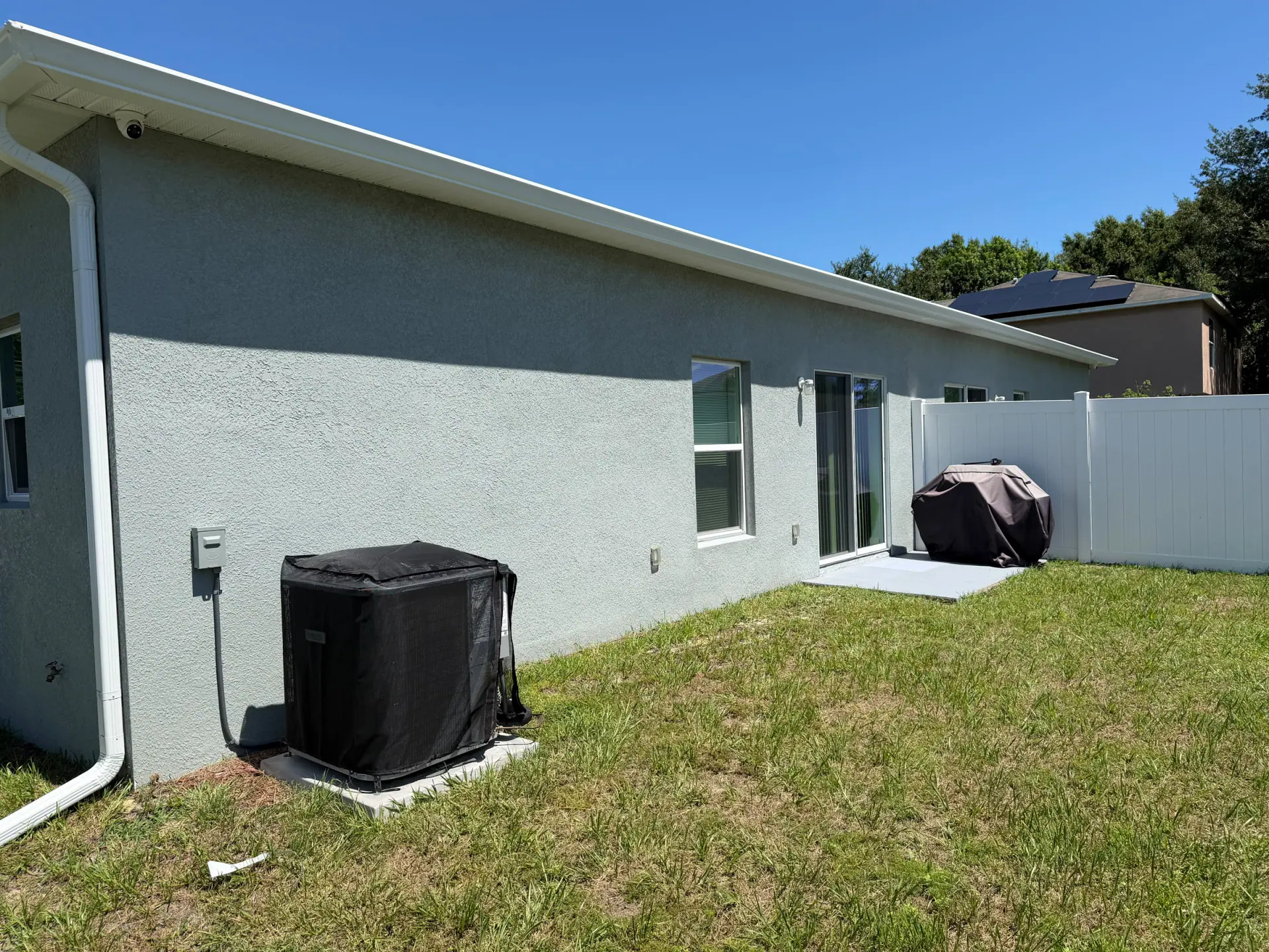 White gutter and downspout installed along the rear roofline of a Florida home